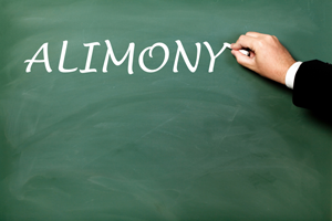 A hand writing alimony in white chalk on a chalk board